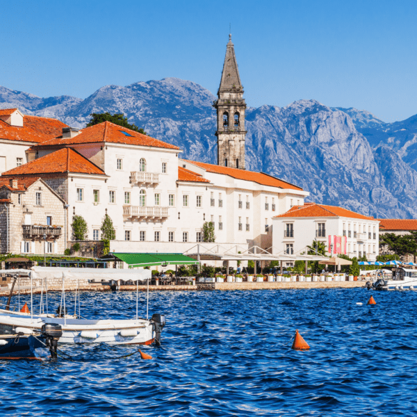 Montenegro village by blue waters and mountain background