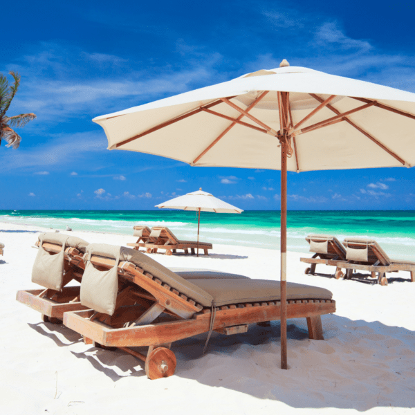 beach chairs in caribbean with sun umbrella and blue skies