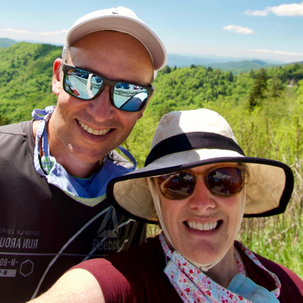 A man and woman with a view of mountains in the background