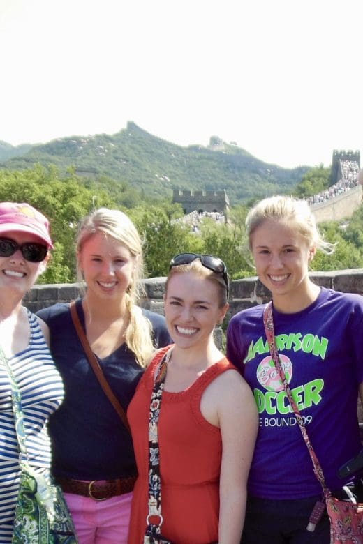 five people posing at great wall looking happy on a sunny day