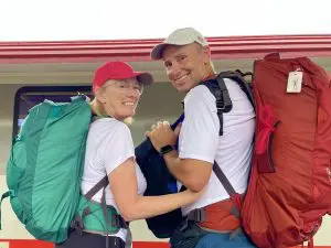 Woman and man standing with backpacks at train station