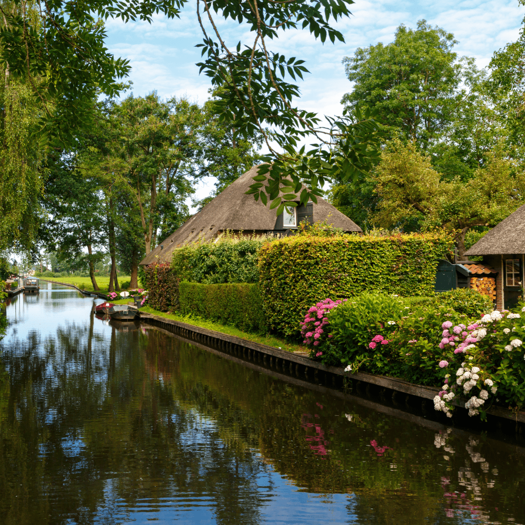 canals in the countryside of Giethoorn with straw thatched roofed houses
