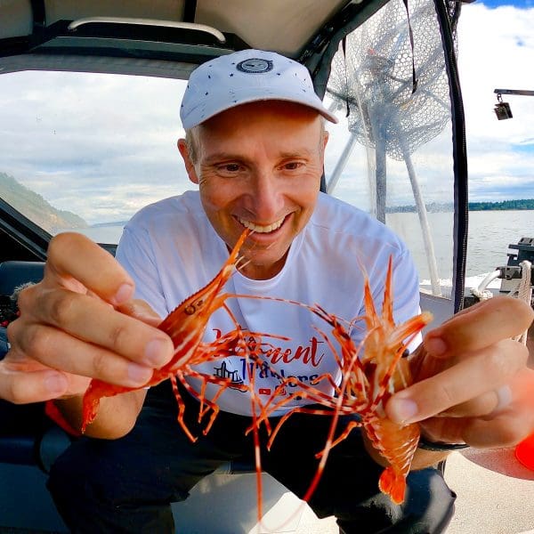 John holding two shrimp in the San Juan Islands