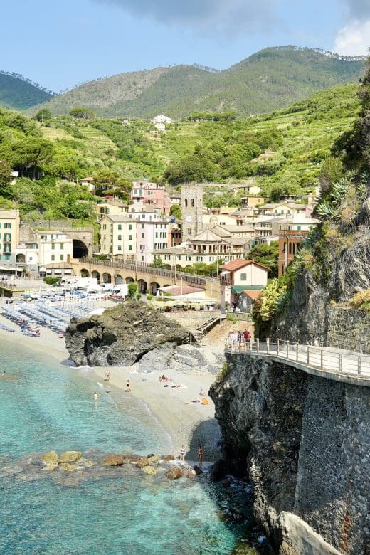 View of the coast with beautiful blue water and rocky cliffs with walkway in Cinque Terre
