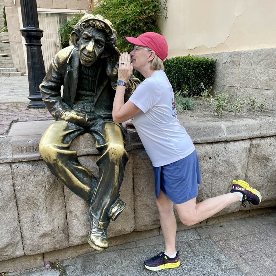 woman whispering in the ear of a statue