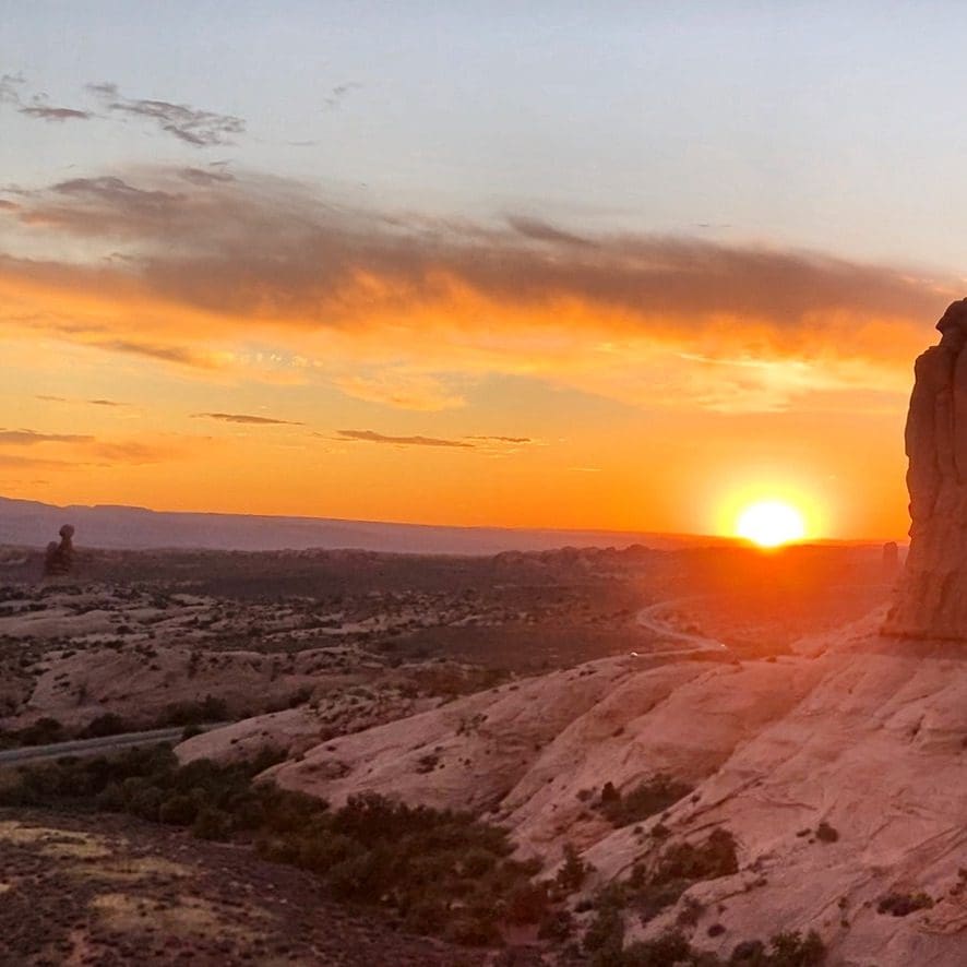 a view of sunset with orange sky and wide vista