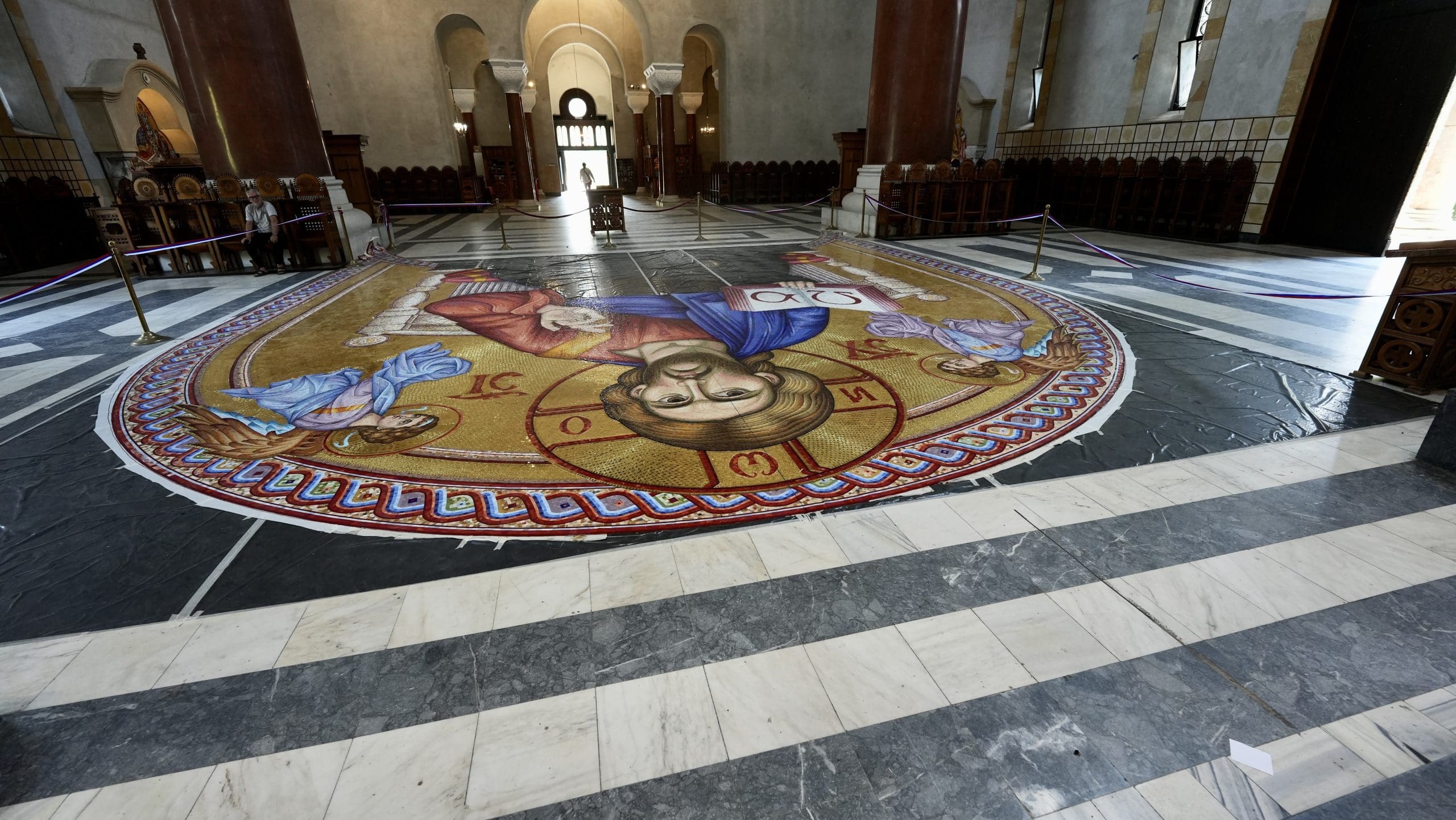 tiles laid out on floor of church with Jesus at the top
